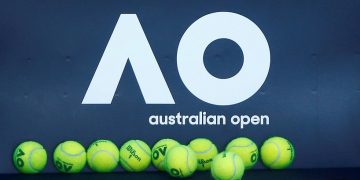 FILE PHOTO: Tennis - Australian Open - Melbourne, Australia, January 14, 2018. Tennis balls are pictured in front of the Australian Open logo before the tennis tournament. REUTERS/Thomas Peter/File Photo