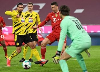 Bayern Munich's Polish forward Robert Lewandowski (C) shoots to score his team's first goal during the German first division Bundesliga football match between FC Bayern Munich and BVB Borussia Dortmund in Munich, southern Germany, on March 6, 2021. (Photo by ANDREAS GEBERT / POOL / AFP) / DFL REGULATIONS PROHIBIT ANY USE OF PHOTOGRAPHS AS IMAGE SEQUENCES AND/OR QUASI-VIDEO (Photo by ANDREAS GEBERT/POOL/AFP via Getty Images)
