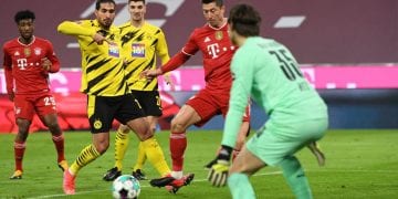Bayern Munich's Polish forward Robert Lewandowski (C) shoots to score his team's first goal during the German first division Bundesliga football match between FC Bayern Munich and BVB Borussia Dortmund in Munich, southern Germany, on March 6, 2021. (Photo by ANDREAS GEBERT / POOL / AFP) / DFL REGULATIONS PROHIBIT ANY USE OF PHOTOGRAPHS AS IMAGE SEQUENCES AND/OR QUASI-VIDEO (Photo by ANDREAS GEBERT/POOL/AFP via Getty Images)