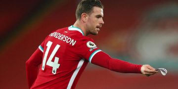 LIVERPOOL, ENGLAND - FEBRUARY 20: Jordan Henderson of Liverpool hands over the captains armband as he goes off injured during the Premier League match between Liverpool and Everton at Anfield on February 20, 2021 in Liverpool, United Kingdom. Sporting stadiums around the UK remain under strict restrictions due to the Coronavirus Pandemic as Government social distancing laws prohibit fans inside venues resulting in games being played behind closed doors. (Photo by Robbie Jay Barratt - AMA/Getty Images)