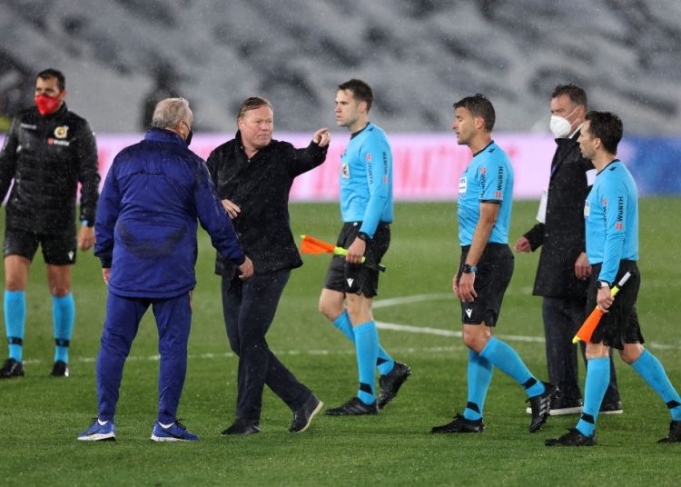 MADRID, SPAIN - APRIL 10: Ronald Koeman, Head Coach of FC Barcelona talks with Referee, Jesus Gil Manzano following the La Liga Santander match between Real Madrid and FC Barcelona at Estadio Alfredo Di Stefano on April 10, 2021 in Madrid, Spain. Sporting stadiums around Spain remain under strict restrictions due to the Coronavirus Pandemic as Government social distancing laws prohibit fans inside venues resulting in games being played behind closed doors. (Photo by Angel Martinez/Getty Images)